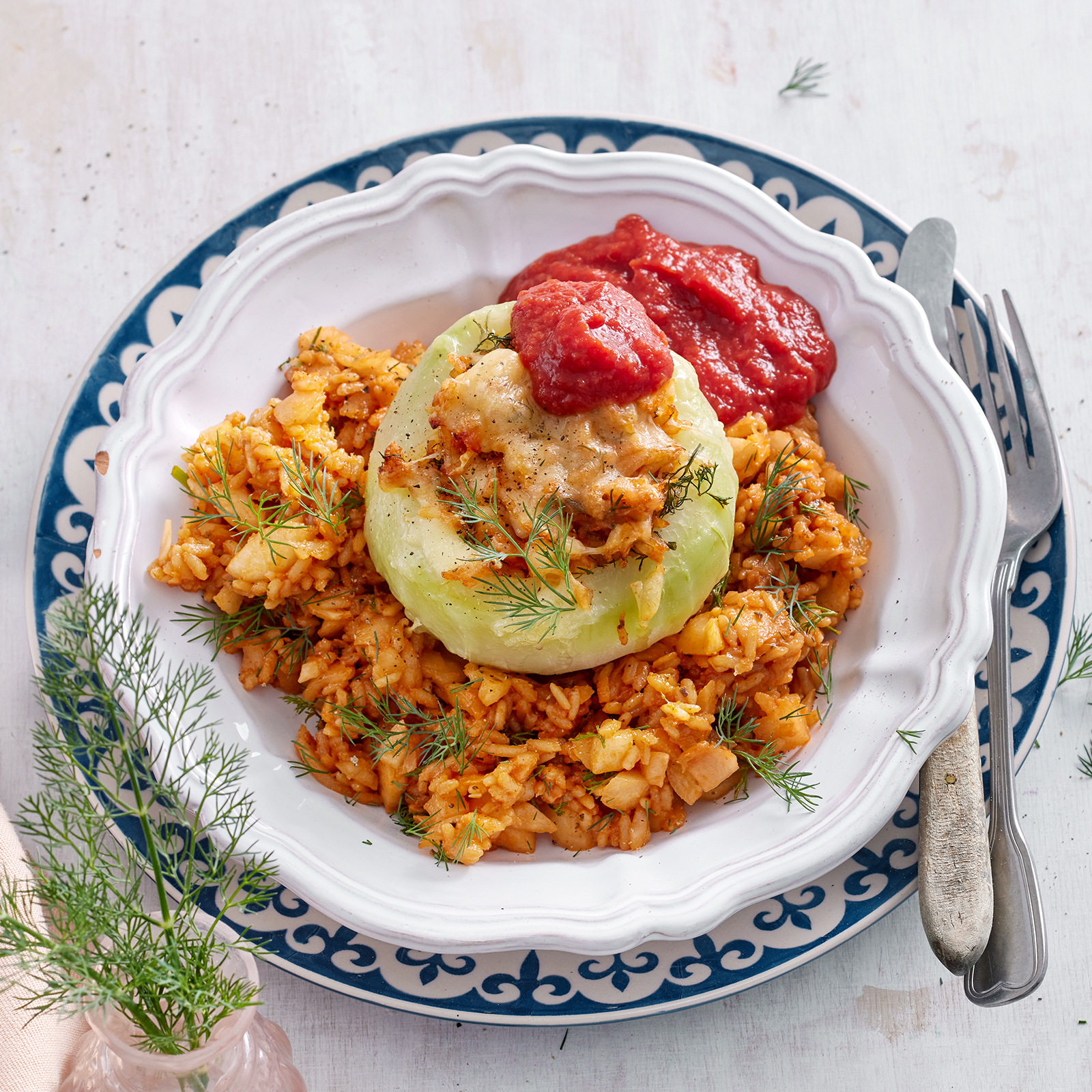 Kohlrabi mit Reisfüllung und Tomatensoße auf einem Teller.