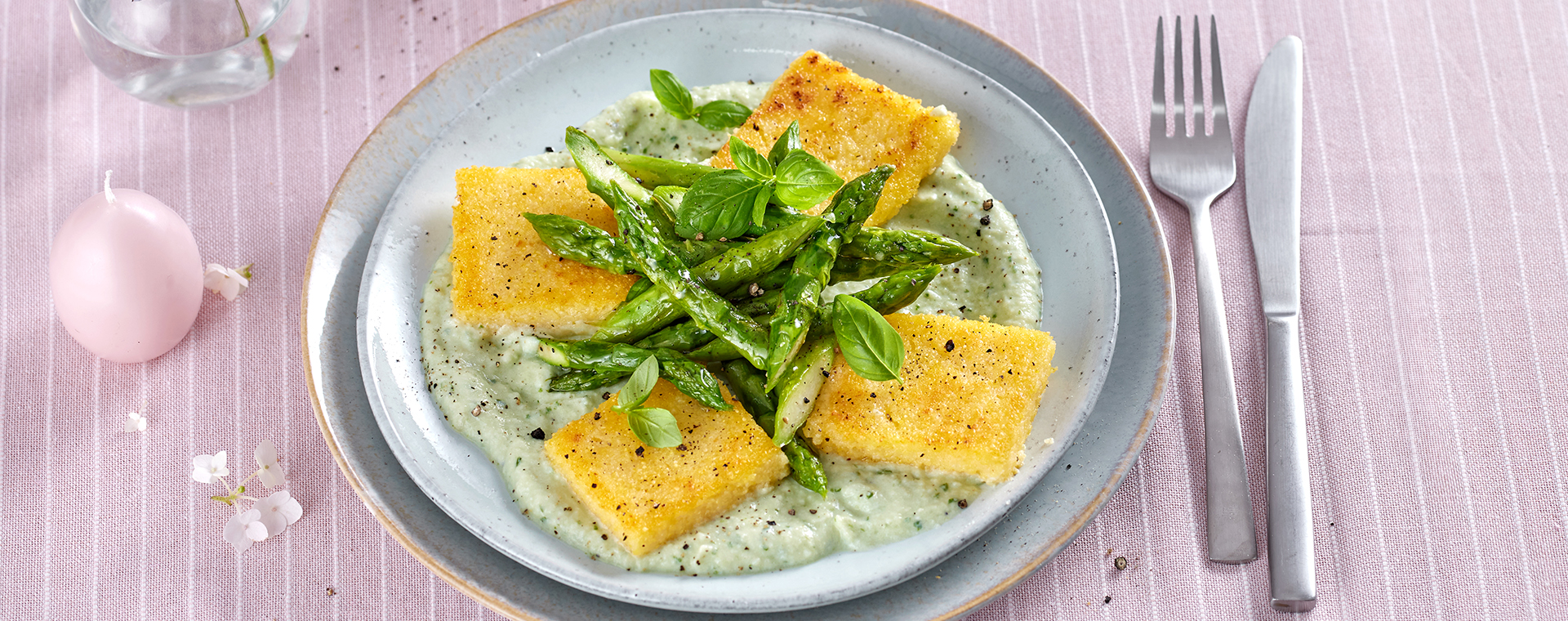 Polentaschnitten mit grünem Spargel, angerichtet auf Kohlrabi-Ricotta-Creme und garniert mit Basilikum.